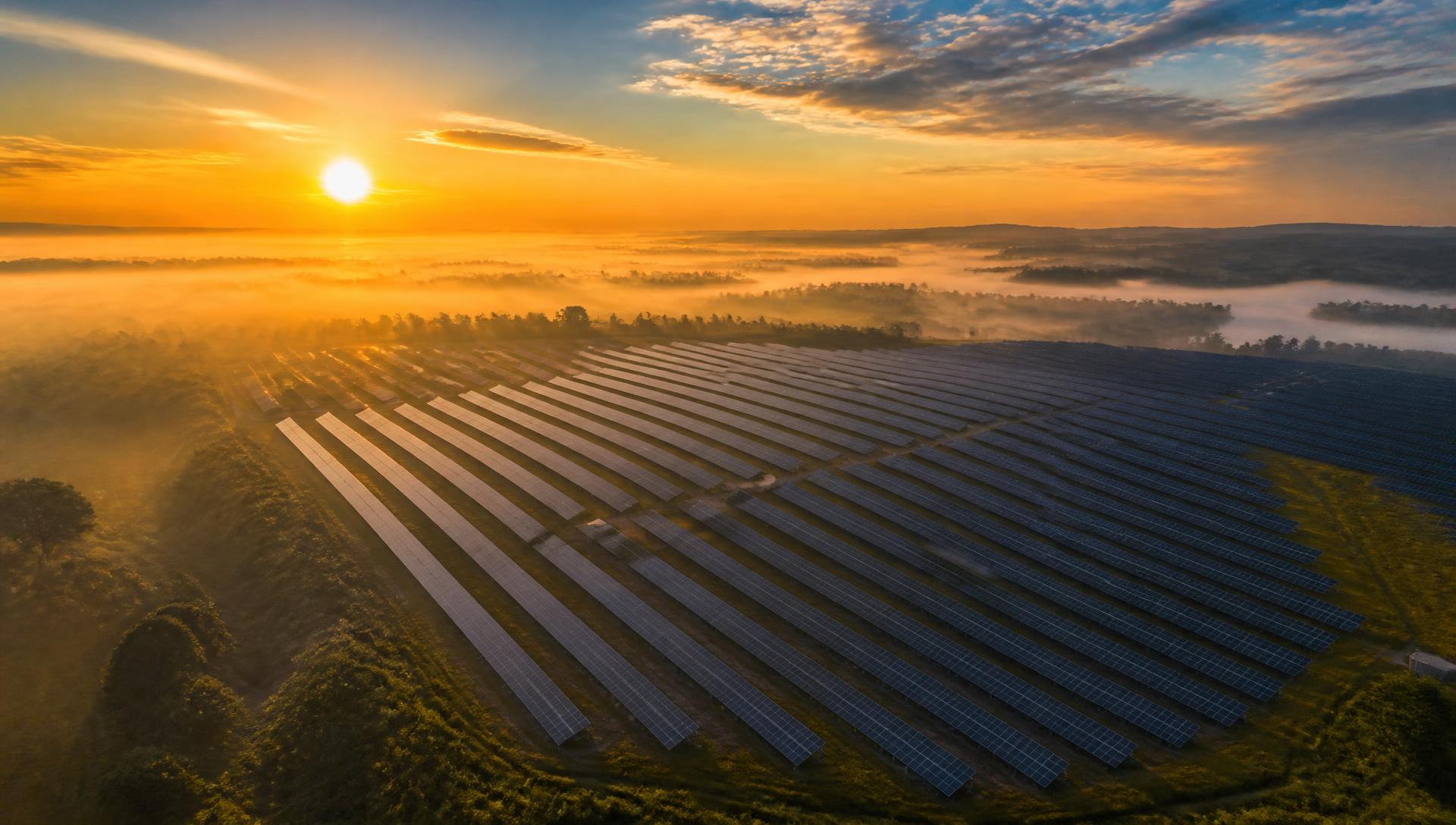 Aerial view of a large solar farm at sunrise